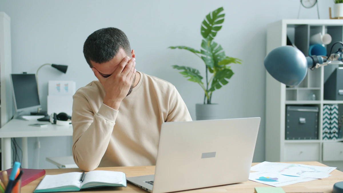 Chef sitzt müde vor dem Laptop