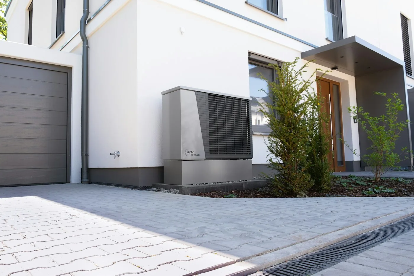 Wärmepumpe vor einem modernen Wohnhaus