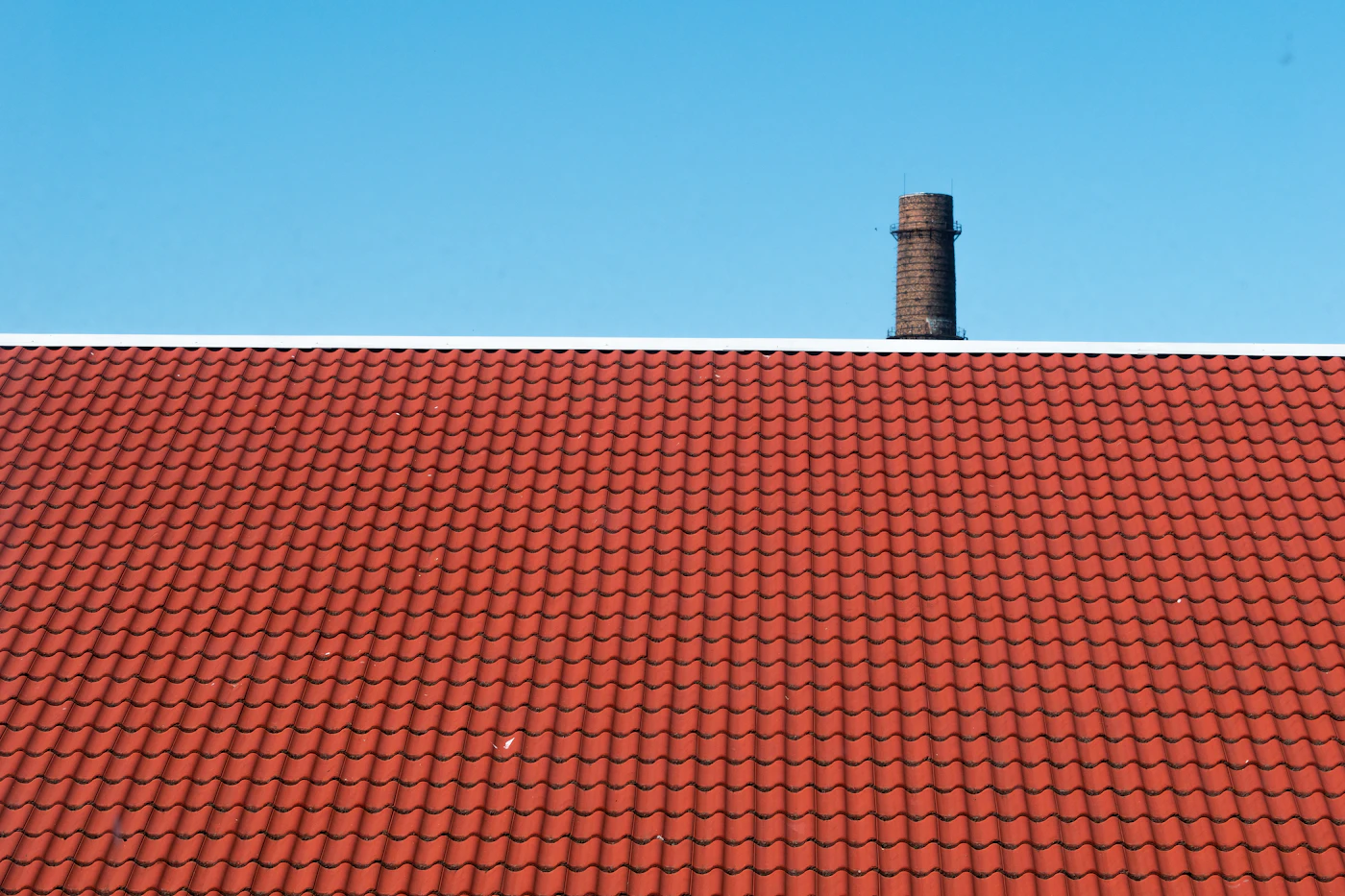 Neu eingedecktes rotes Ziegeldach mit Kamin