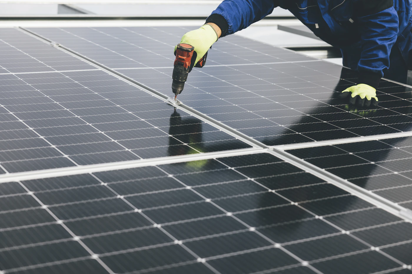 Monteur befestigt eine PV-Anlage auf dem Dach